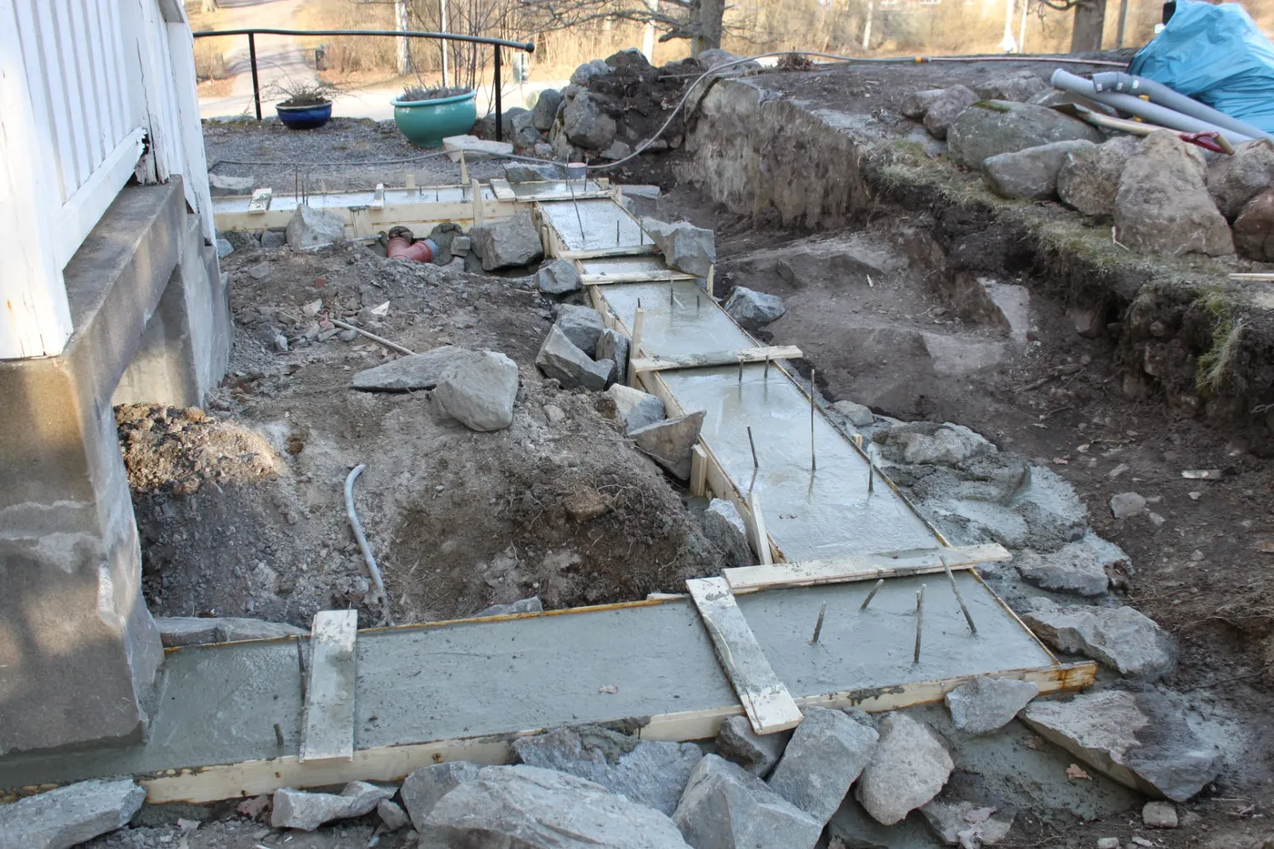 Gjuten betongremsa med formvirke längs husgrunden