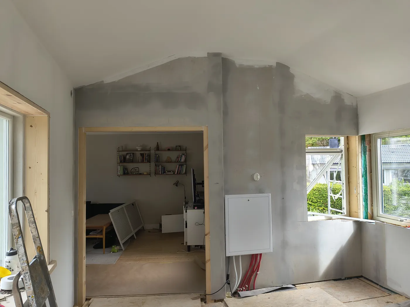 Färdig öppning invändigt med foder i trä och nytt hörnfönster, spacklat och klart för målning