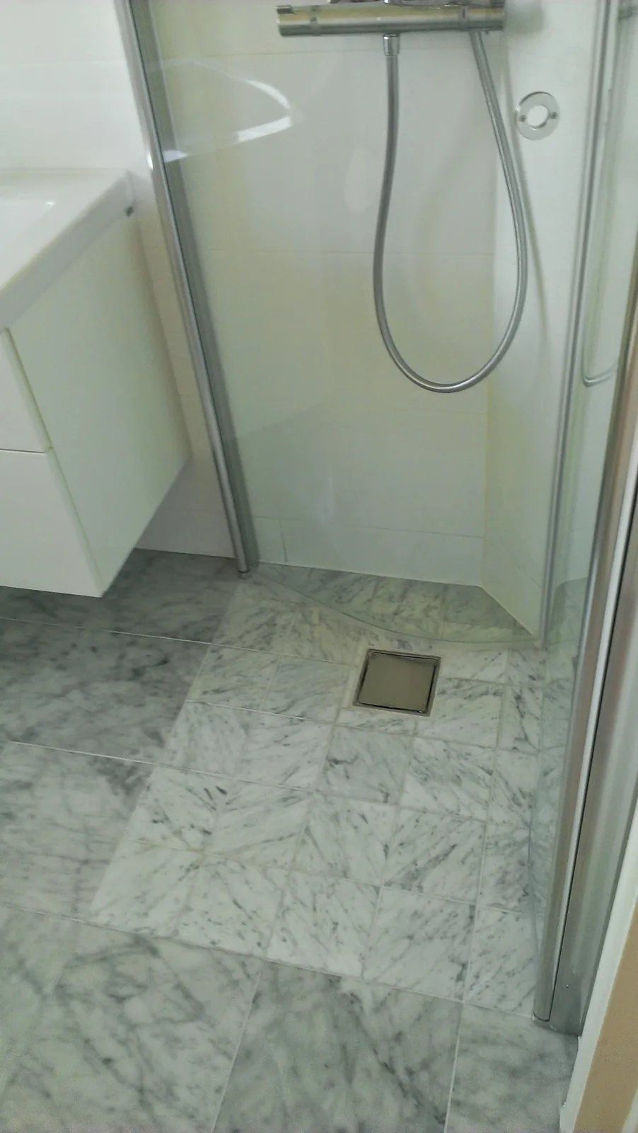 Badrumsrenovering med marmorklinker i Bromma, bild 1 av 2
