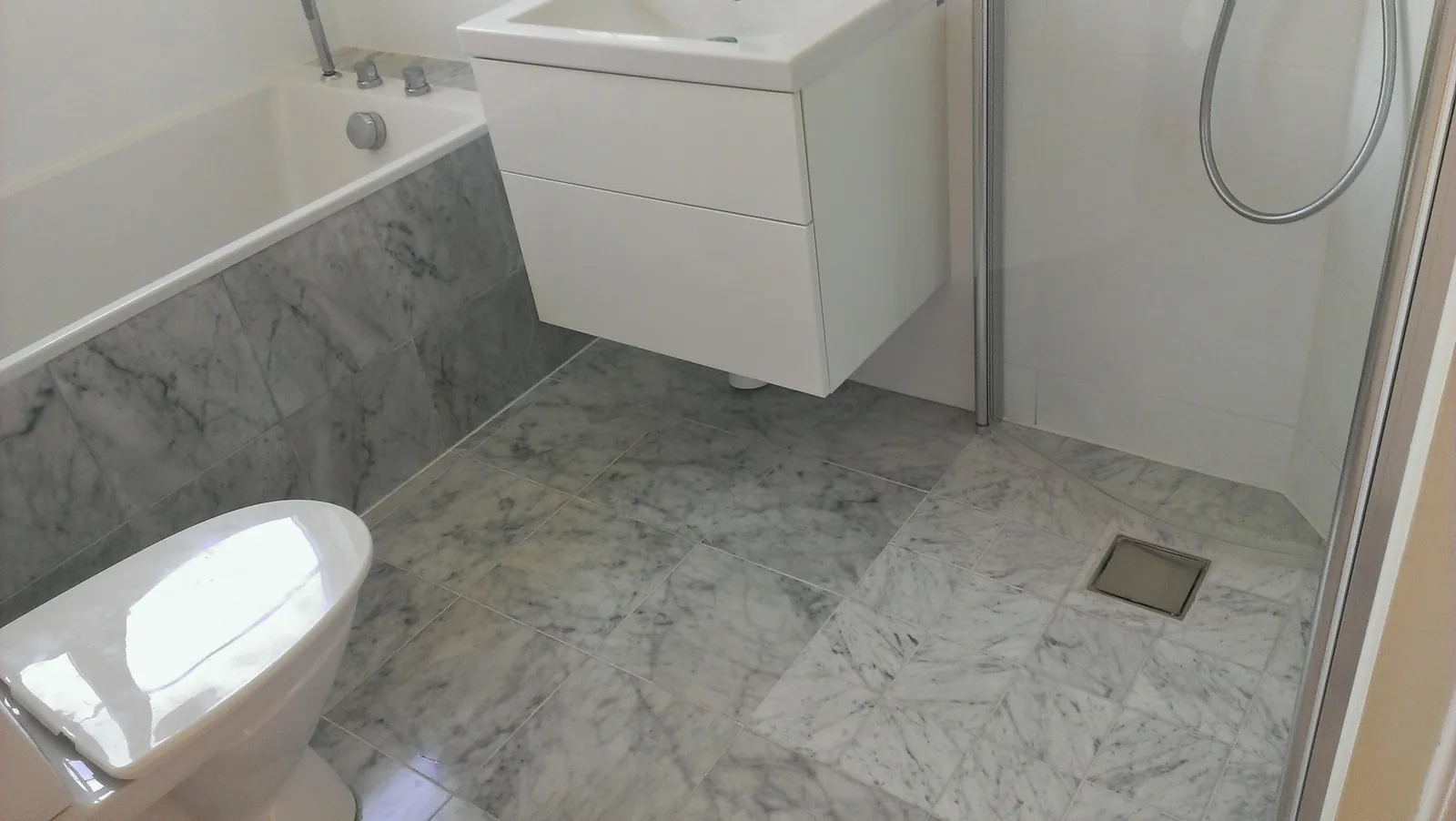 Badrumsrenovering med marmorklinker i Bromma, bild 2 av 2